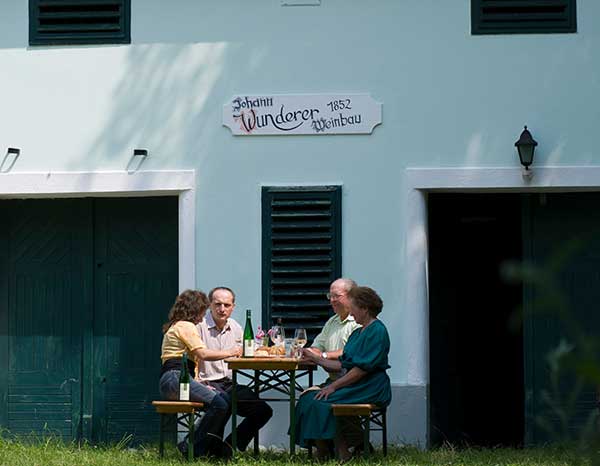 Winzer Liane und Johann Wunderer sitzen vor dem Presshaus des Weingut in Ebersbrunn